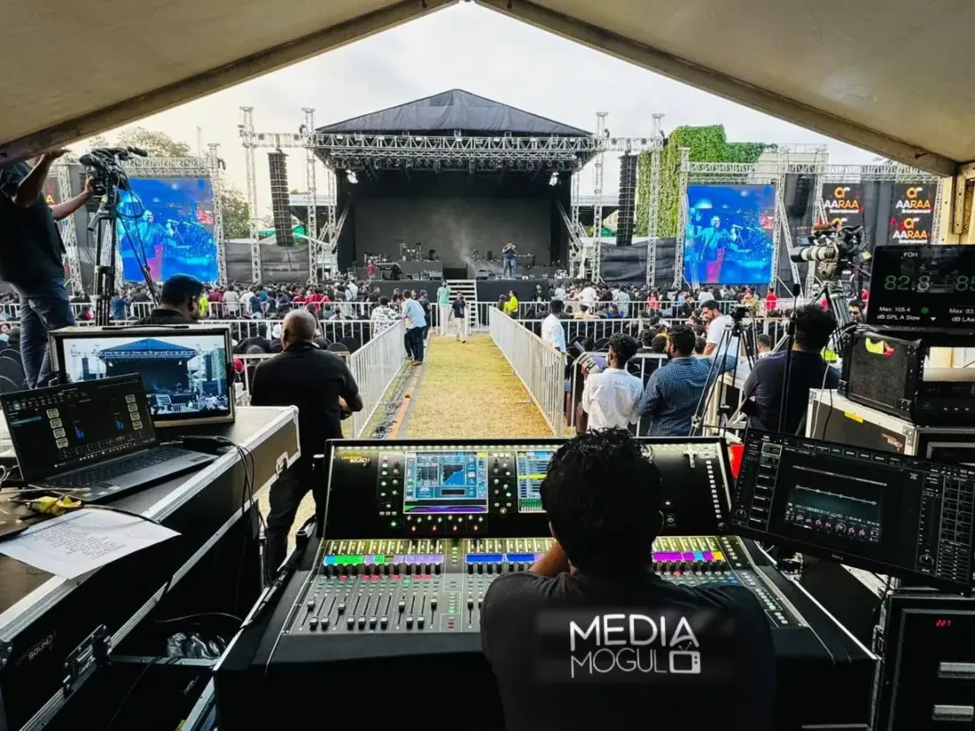 Front of house engineer at a festival mix position with stage and LED screens
